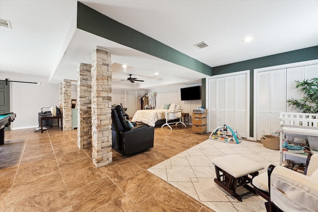 living room with decorative columns, ceiling fan, billiards, and a barn door