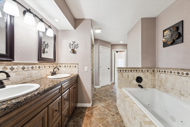 bathroom with vanity and tiled bath