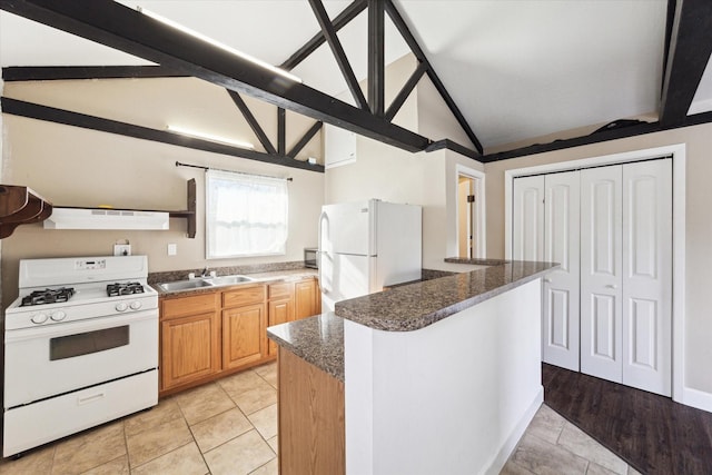 kitchen with white appliances, extractor fan, sink, dark stone countertops, and vaulted ceiling