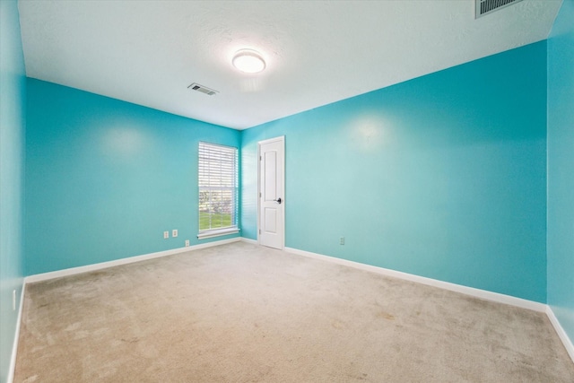 unfurnished room with a textured ceiling and carpet floors