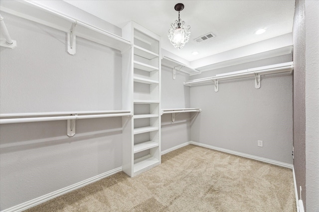 walk in closet featuring light colored carpet