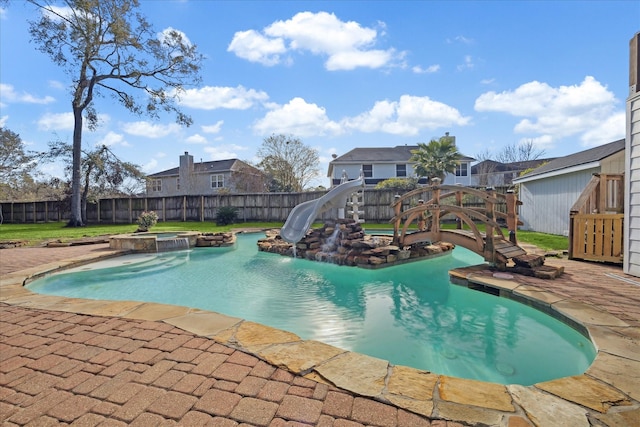 view of pool featuring an in ground hot tub and a water slide