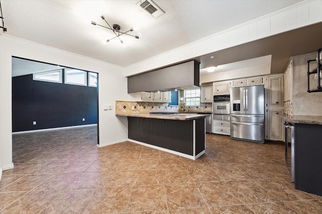 kitchen featuring a textured ceiling, appliances with stainless steel finishes, a kitchen bar, backsplash, and kitchen peninsula