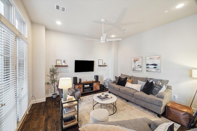 living room with dark hardwood / wood-style flooring and ceiling fan