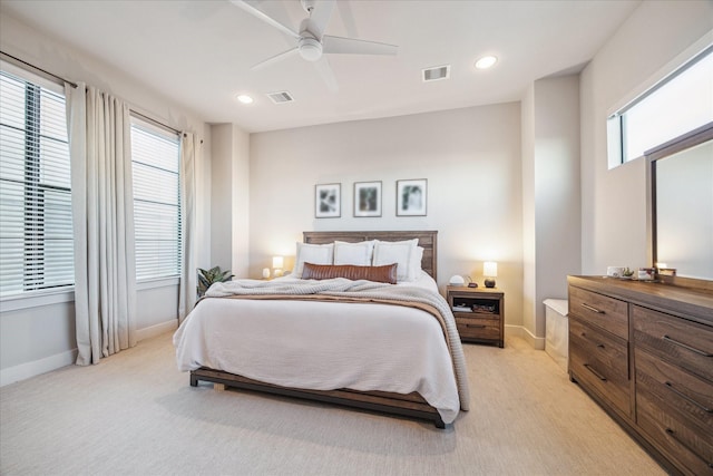 bedroom with light carpet, multiple windows, and ceiling fan