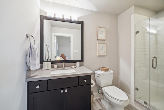 bathroom featuring hardwood / wood-style floors, vanity, an enclosed shower, and toilet