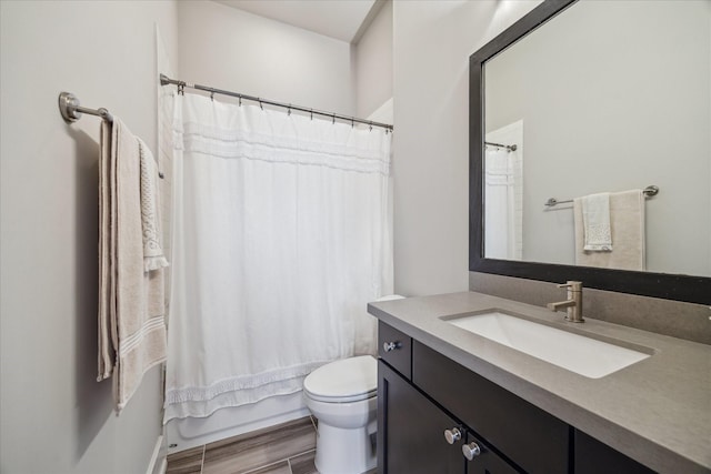 full bathroom featuring toilet, hardwood / wood-style floors, vanity, and shower / tub combo with curtain