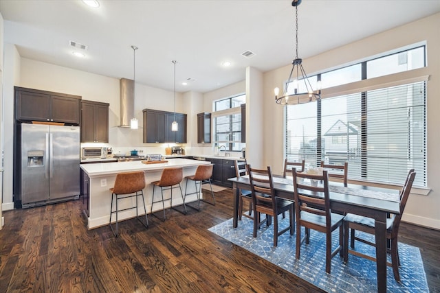 dining room featuring sink, dark hardwood / wood-style floors, and an inviting chandelier