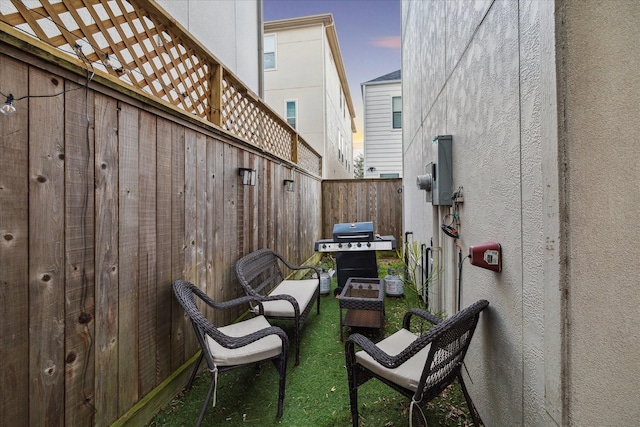 patio terrace at dusk featuring grilling area