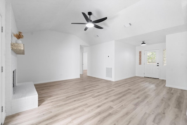 unfurnished living room featuring ceiling fan, a fireplace, light hardwood / wood-style floors, and vaulted ceiling