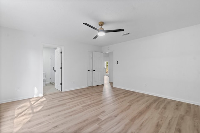 unfurnished bedroom with light wood-type flooring, ensuite bathroom, and ceiling fan