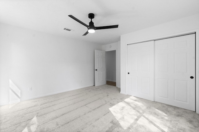 unfurnished bedroom with ceiling fan, light colored carpet, and a closet