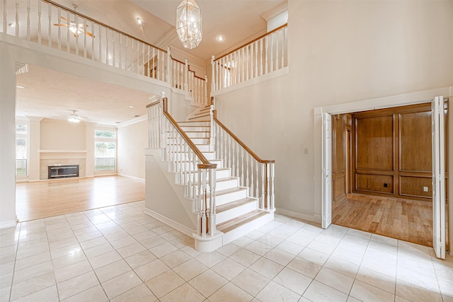 stairway with tile patterned floors and a notable chandelier