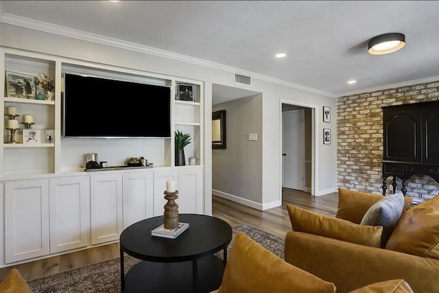 living room featuring dark hardwood / wood-style floors, built in features, and crown molding