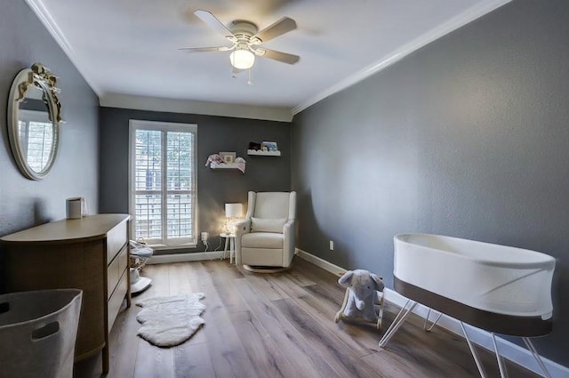 living area featuring light hardwood / wood-style floors, ceiling fan, and ornamental molding