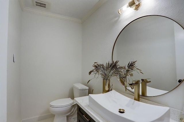 bathroom with vanity, toilet, and ornamental molding