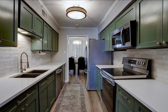 kitchen with green cabinets, sink, and stainless steel appliances