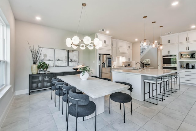 tiled dining room with sink and a notable chandelier