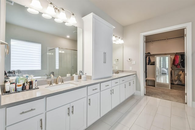 bathroom featuring tile patterned flooring, vanity, and walk in shower