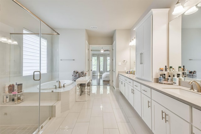 bathroom with tile patterned flooring, vanity, ceiling fan, and plus walk in shower