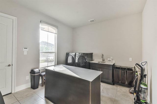 interior space with dark brown cabinetry, light tile patterned floors, sink, and washing machine and clothes dryer