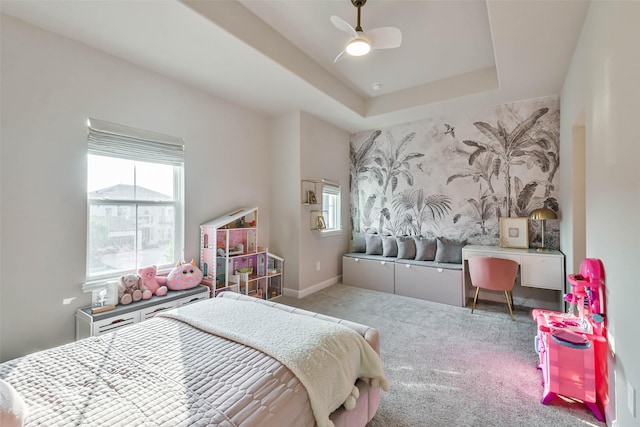 bedroom with carpet, ceiling fan, and a raised ceiling