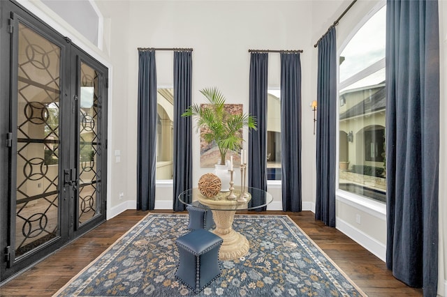 foyer entrance with french doors and dark hardwood / wood-style floors