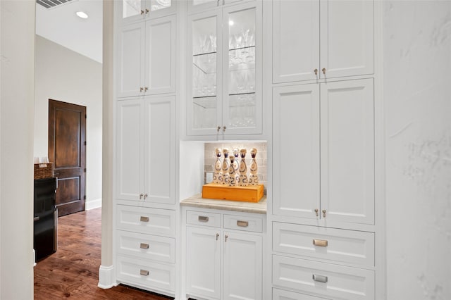 interior space featuring dark hardwood / wood-style flooring and white cabinets