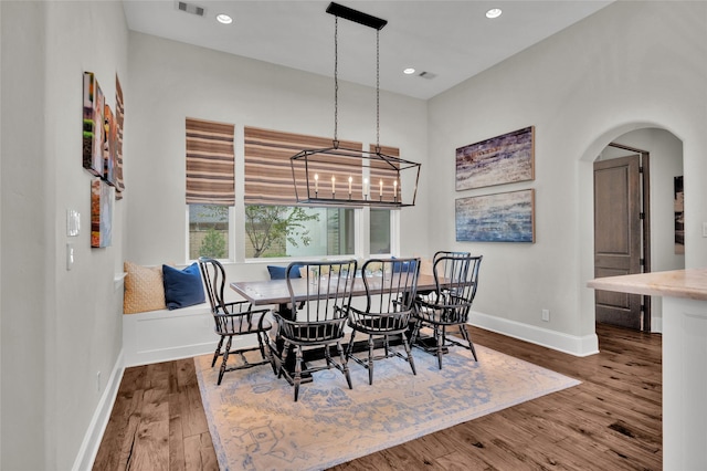 dining area with hardwood / wood-style flooring and a notable chandelier