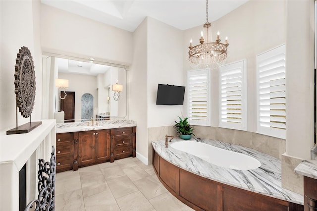 bathroom featuring tile patterned flooring, a bathtub, an inviting chandelier, and vanity