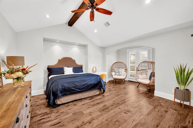 bedroom featuring ceiling fan, hardwood / wood-style floors, and vaulted ceiling with beams