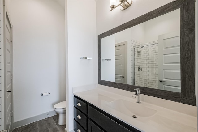 bathroom with toilet, an enclosed shower, and vanity