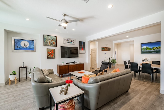 living room featuring ceiling fan and light hardwood / wood-style flooring