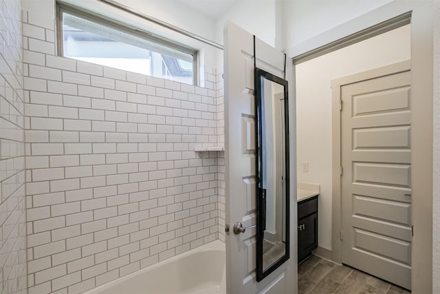 bathroom featuring vanity and tiled shower / bath