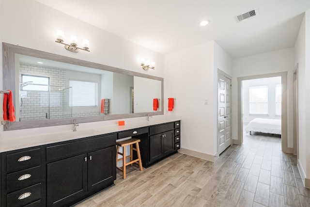 bathroom featuring wood-type flooring, vanity, and walk in shower