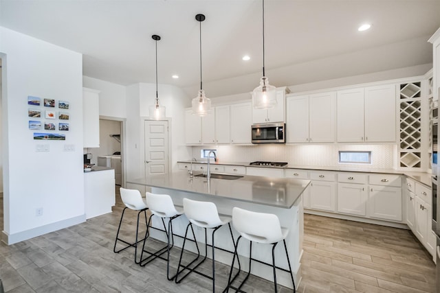 kitchen featuring white cabinets, pendant lighting, sink, and stainless steel appliances