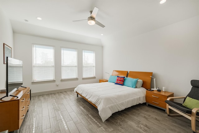 bedroom with ceiling fan, dark wood-type flooring, and multiple windows