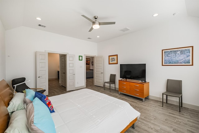 bedroom featuring ceiling fan, light hardwood / wood-style floors, and lofted ceiling