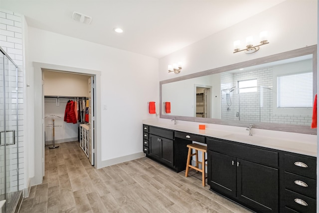 bathroom featuring vanity, hardwood / wood-style flooring, and a shower with shower door