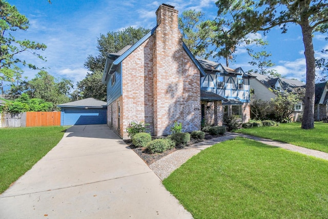 view of side of property with a lawn, a garage, and a balcony