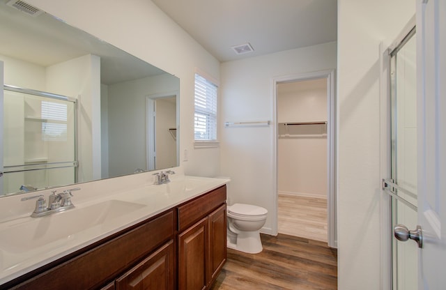 bathroom with vanity, hardwood / wood-style flooring, toilet, and a shower with shower door