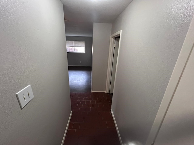 hall with dark tile patterned flooring