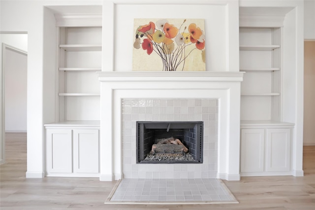 interior details with built in features, a fireplace, and hardwood / wood-style flooring