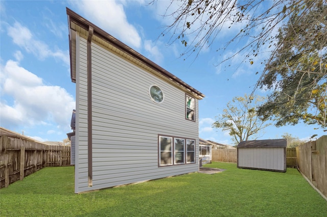 rear view of house with a yard and a storage shed