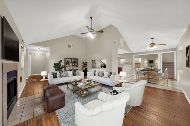 living room featuring ceiling fan, wood-type flooring, and vaulted ceiling