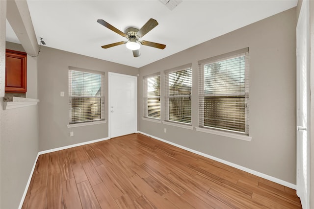 empty room with light hardwood / wood-style flooring and ceiling fan