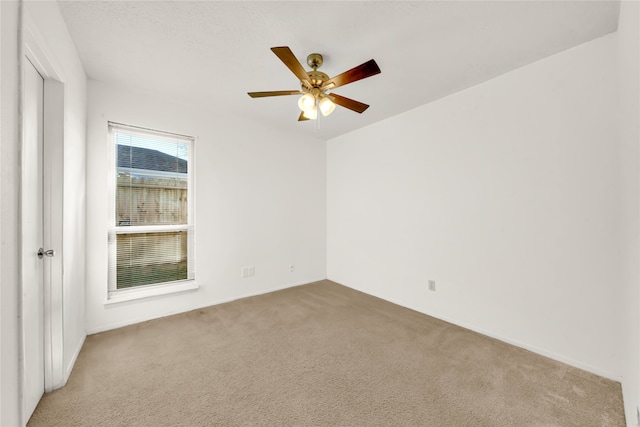 carpeted spare room featuring ceiling fan