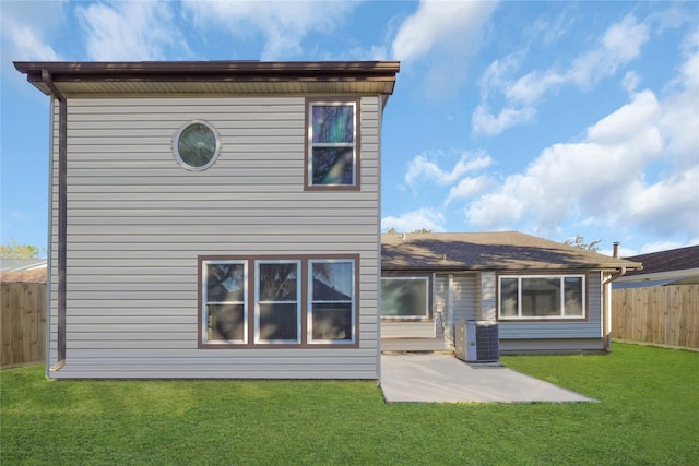 back of house featuring a patio, a yard, and central AC