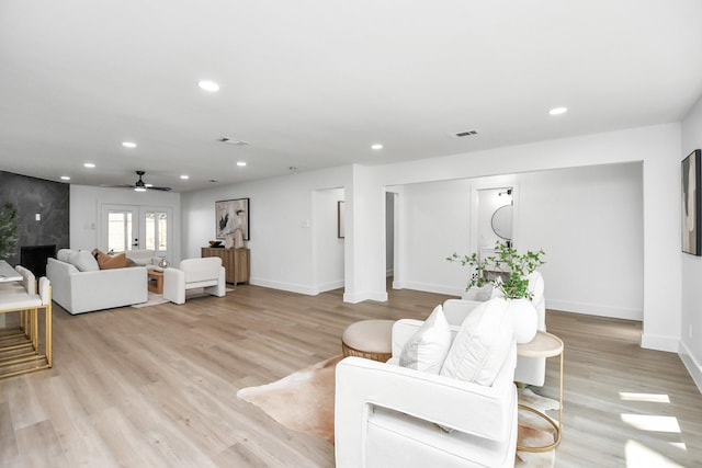 living room featuring ceiling fan, light wood-type flooring, and french doors