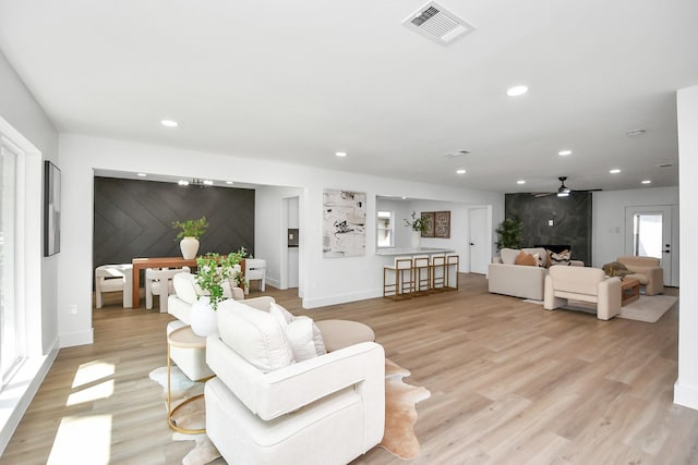 living room with ceiling fan and light hardwood / wood-style flooring